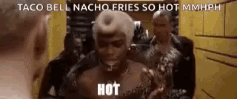 a man is eating a taco bell nacho fries so hot mmmph .