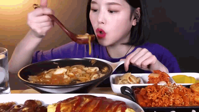 a woman eating a bowl of food with a spoon