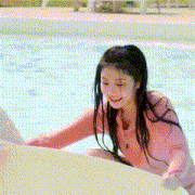a young girl in a pink shirt is playing in a pool .