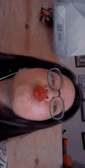 a woman wearing glasses is making a funny face with her red lips