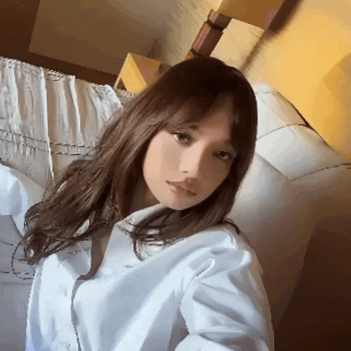 a woman in a white shirt takes a selfie