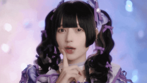a girl with pigtails and a purple dress is making a shhh sign