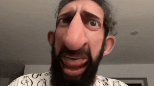 a man with a beard is making a funny face with his tongue out .