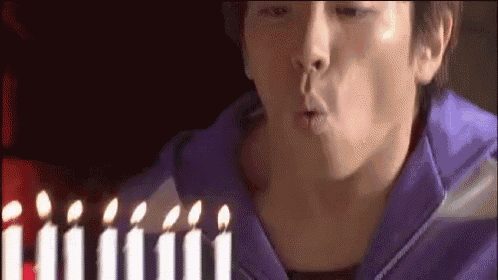 a man blowing out candles on a birthday cake
