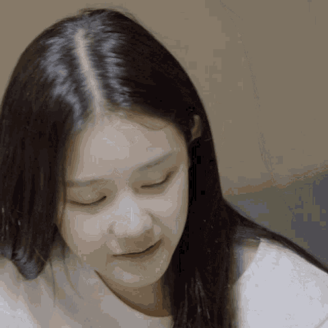 a close up of a woman 's face with a white shirt on
