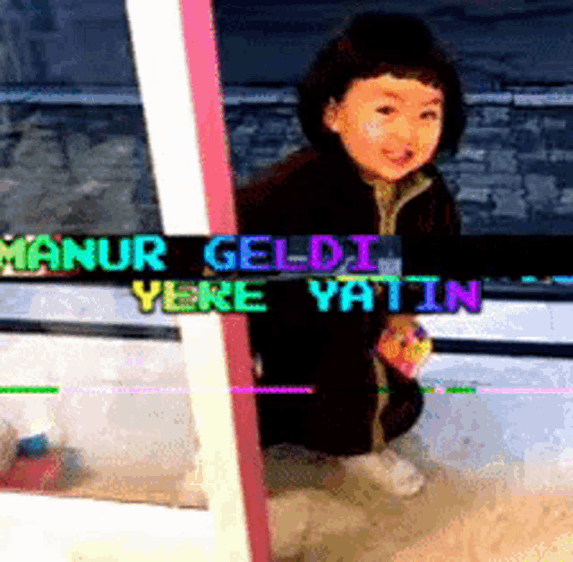 a little girl is kneeling down in front of a sign that says manur geldi yere yatin