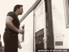 a man in a black shirt is standing next to a white trailer .