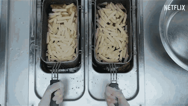 two baskets of french fries are being cooked in a fryer with a netflix logo in the background