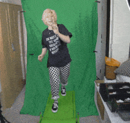 a woman wearing a black shirt that says " junk waste " is walking on a green treadmill