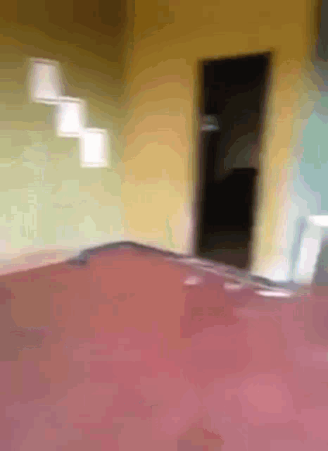 a blurry picture of a bedroom with a red bed and a yellow wall