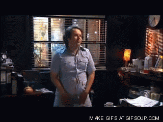 a man in a blue shirt is standing in front of a window with make gifs at gif soup.com written on the bottom