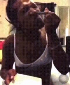 a woman in a white tank top is sitting on a table