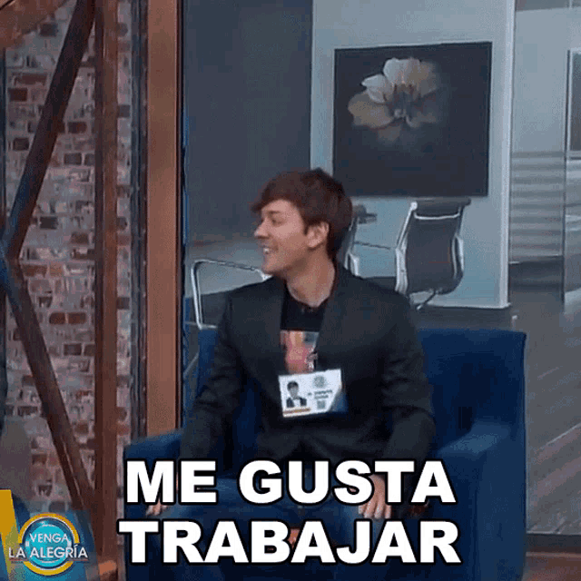 a man in a suit is sitting in a chair with the words me gusta trabajar in front of him