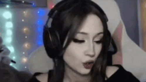a woman wearing headphones is making a funny face in a video game .