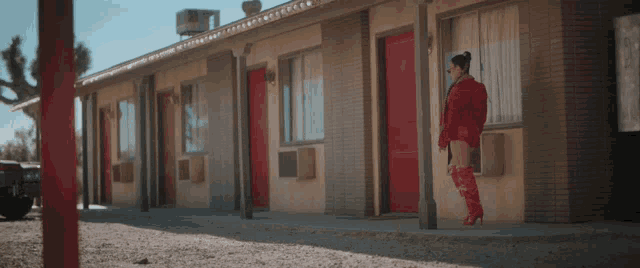 a woman in red boots stands in front of a building
