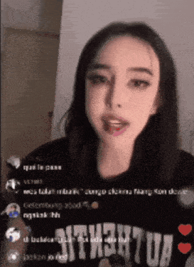 a girl with a tongue sticking out is wearing a shirt that says ' nth3htua ' on it