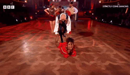 a group of people are dancing on a dance floor with the words strictly come dancing on the bottom