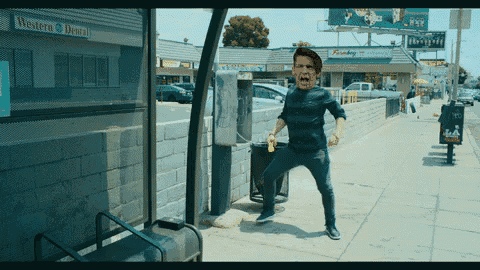 a man standing on a sidewalk in front of a western dental store