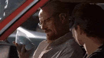a man with glasses is sitting in the driver 's seat of a car with another man .