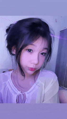 a close up of a girl 's face with purple lights in the background