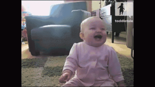 a baby is laughing while sitting on the floor in front of a chair and a sign that says toddlertale