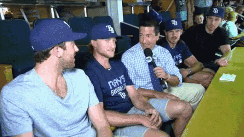 a group of rays baseball players are sitting around a table with a microphone