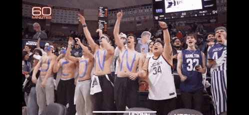 a group of uconn basketball fans are cheering in the stands