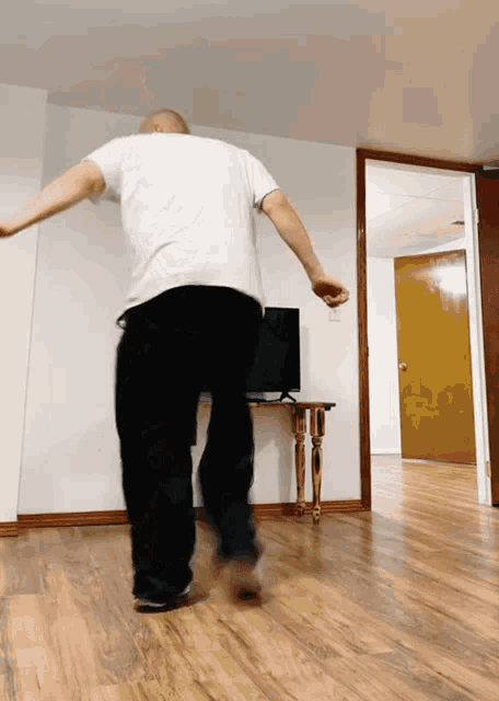 a man in a white shirt and black pants is dancing