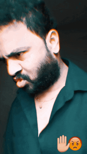 a man with a beard is wearing a green shirt and has an angry face on his chest