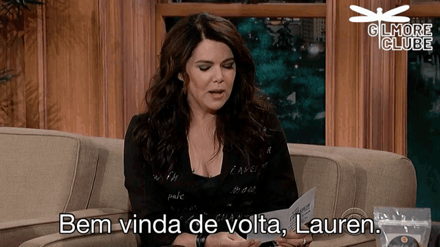 a woman sitting on a couch with the words bem vindo de volta lauren written below her