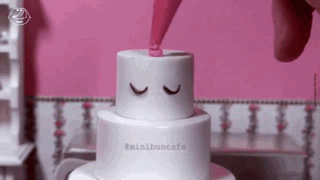 a white cake with the words minibuncafe on the bottom of it