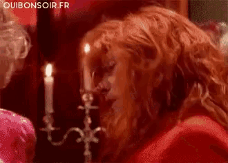 a man with a beard is sitting in front of a candle holder with the words ouibonsoir.fr written on the bottom