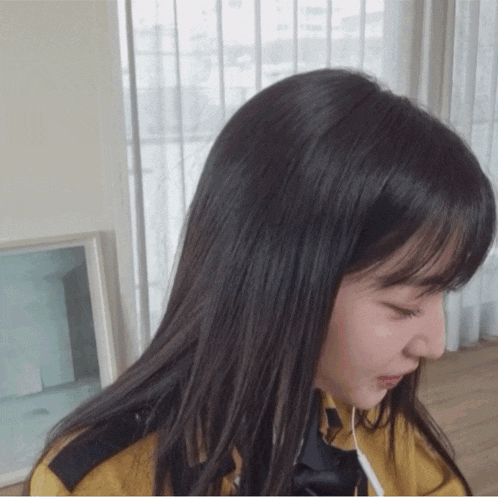 a girl with long black hair is wearing a yellow jacket and tie