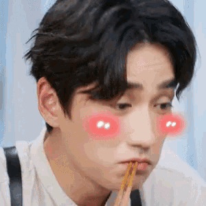 a young man with chopsticks in his mouth has red cheeks