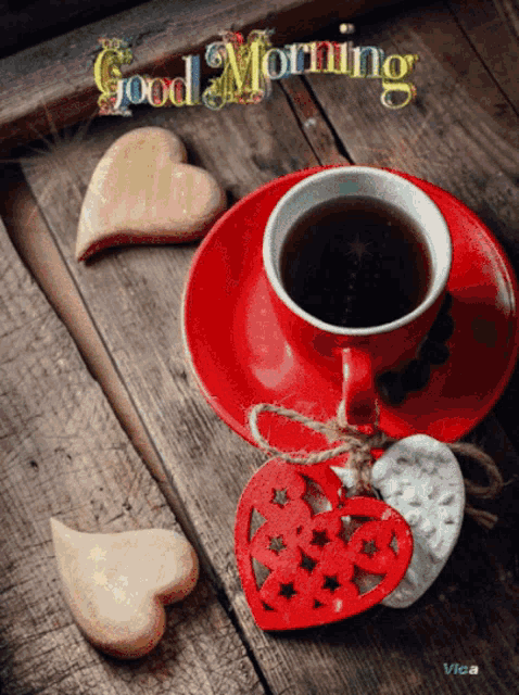 a cup of coffee sits on a saucer next to heart shaped cookies and the words good morning