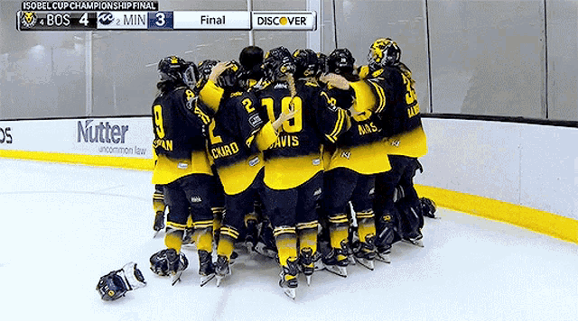 a group of hockey players huddle on the ice with the scoreboard behind them that says discover