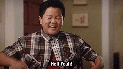 a young boy in a plaid shirt is making a funny face and saying hell yeah .