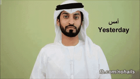a man with a beard wearing a white keffiyeh and a white shirt says yesterday in arabic