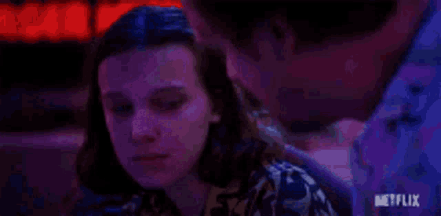a man and a woman are sitting next to each other and looking at each other .