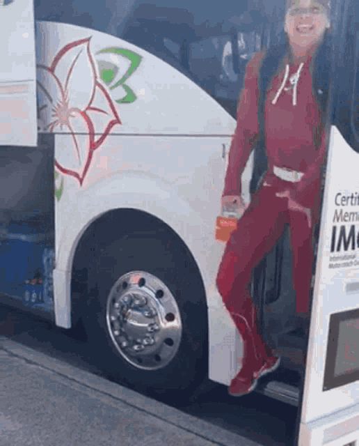 a woman in a red outfit is standing next to a bus that says certified memo
