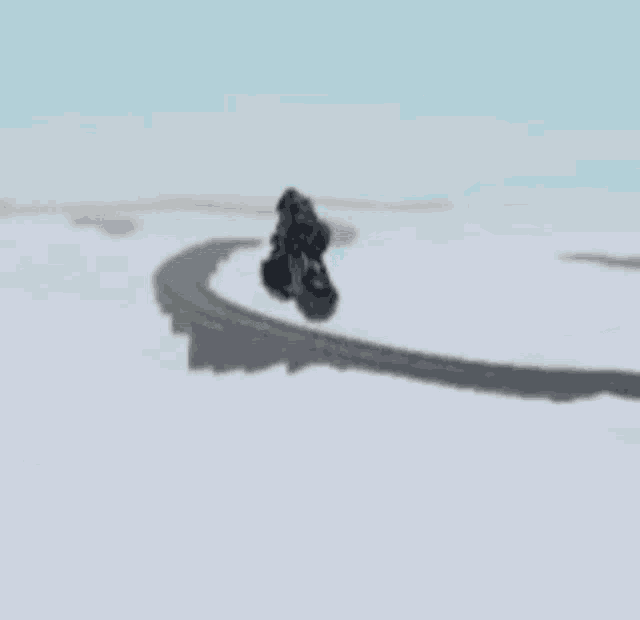 a toy car is flying through the air over a snowy field .