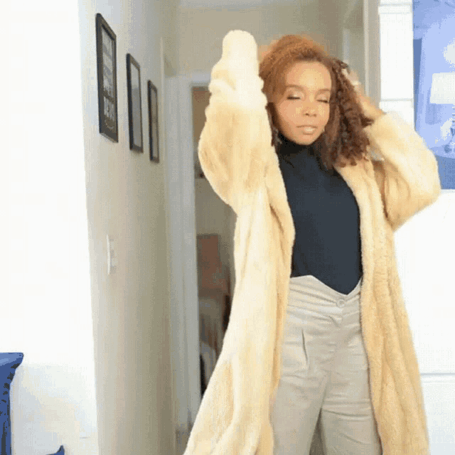 a woman is wearing a fur coat and a black shirt