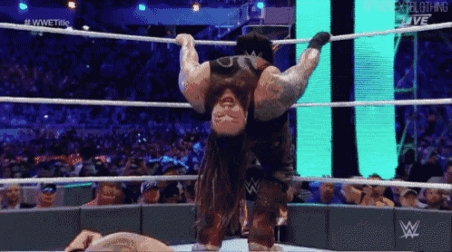a wrestler is hanging upside down in the ring