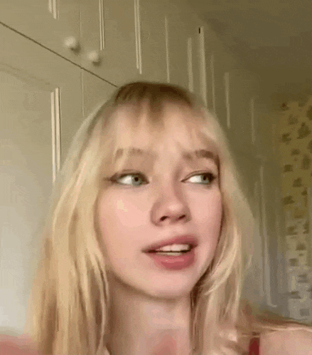 a close up of a young woman with blonde hair and green eyes .