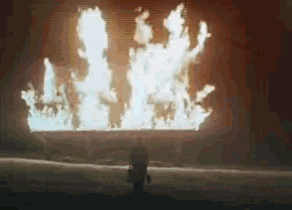 a person standing in front of a large fire .