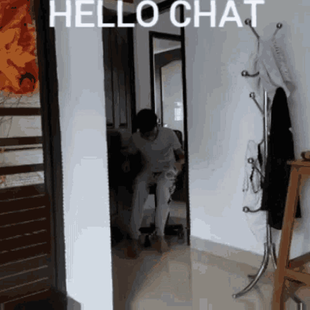 a man sits in a chair in a hallway with the words hello chat written above him