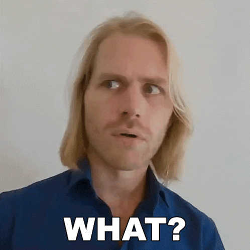 a man with long blonde hair and a blue shirt says " what "