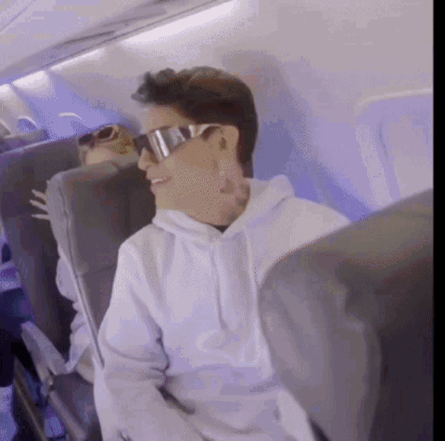 a man wearing sunglasses is sitting in a plane