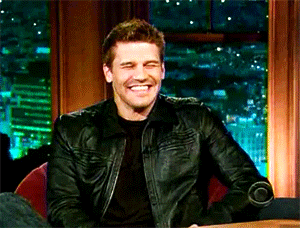 a man in a black leather jacket is smiling