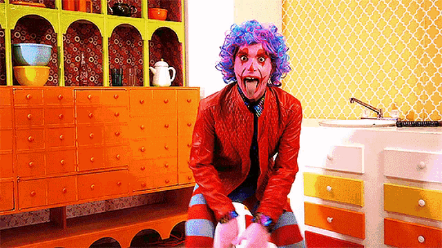 a woman in a clown costume is sitting on a pink rocking horse